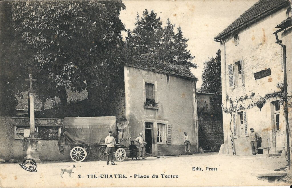 Postcard photo of a French town with brick buildings and a horse-drawn wagon