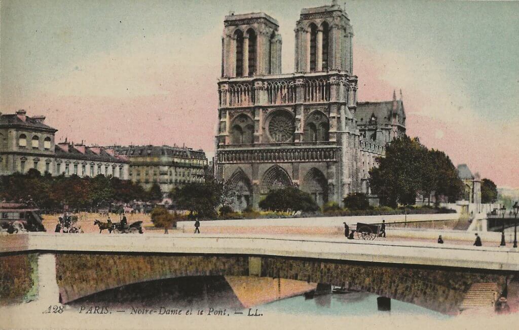 Tinted postcard image of Notre Dame Cathedral, showing horse-drawn vehicles and a hand cart