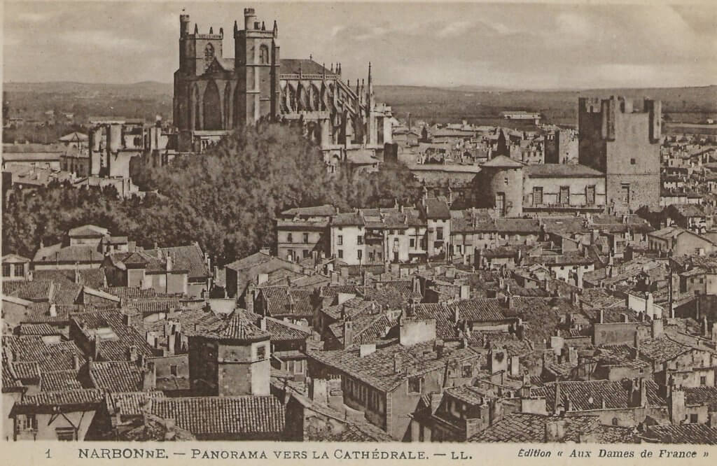 Postcard photo over rooftops of Narbonne, with its Gothic cathedral in the background